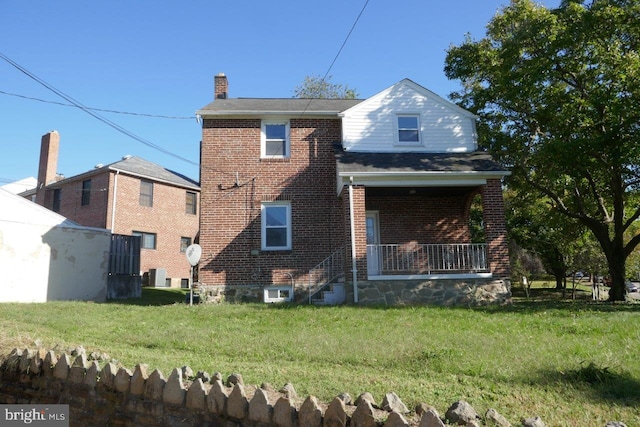 back of property featuring central air condition unit and a lawn