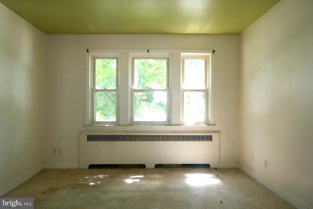 unfurnished room with radiator heating unit