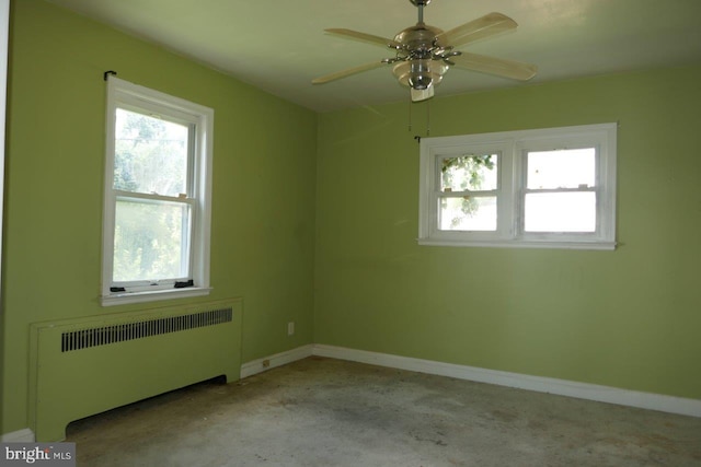 spare room with radiator and ceiling fan