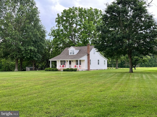 cape cod home featuring covered porch and a front yard