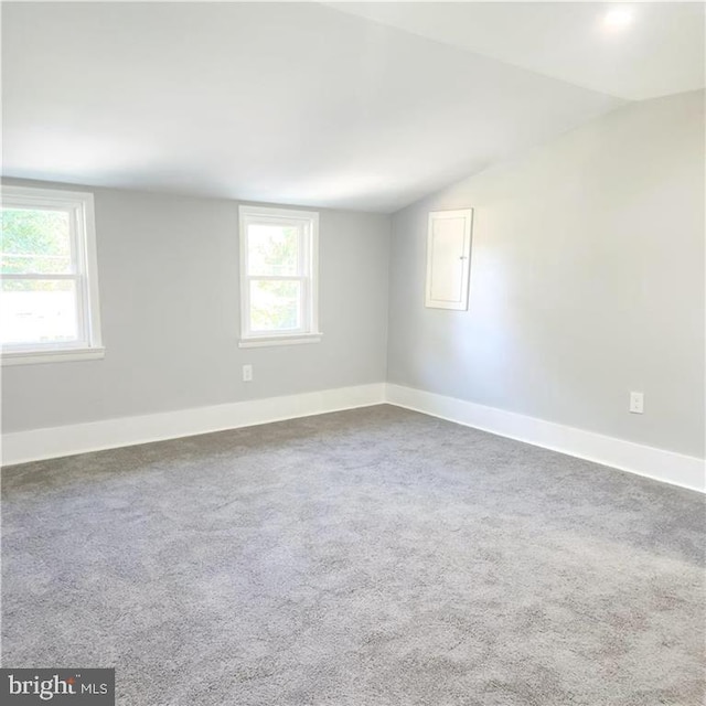 carpeted empty room with lofted ceiling