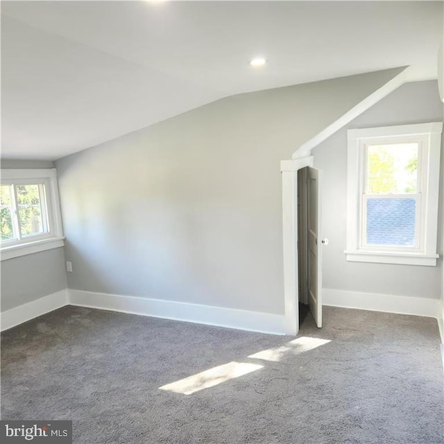 spare room featuring carpet, plenty of natural light, and vaulted ceiling