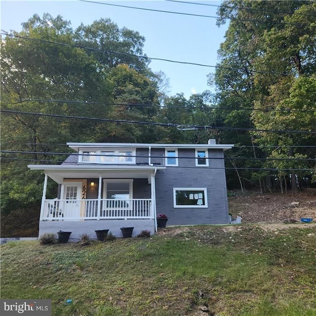 view of front of house with covered porch and a front lawn