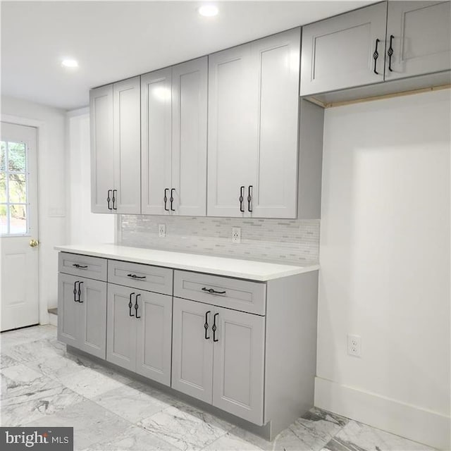 kitchen featuring gray cabinets and tasteful backsplash