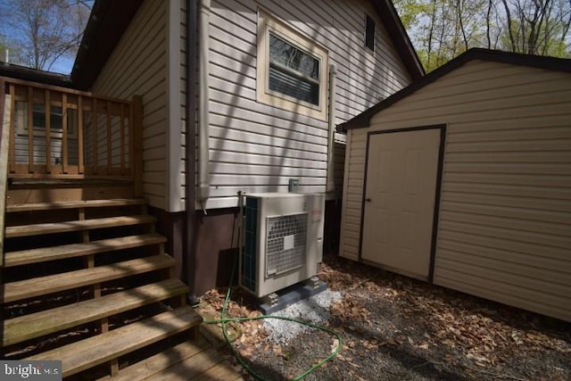 view of side of home with a wooden deck, a storage unit, and ac unit