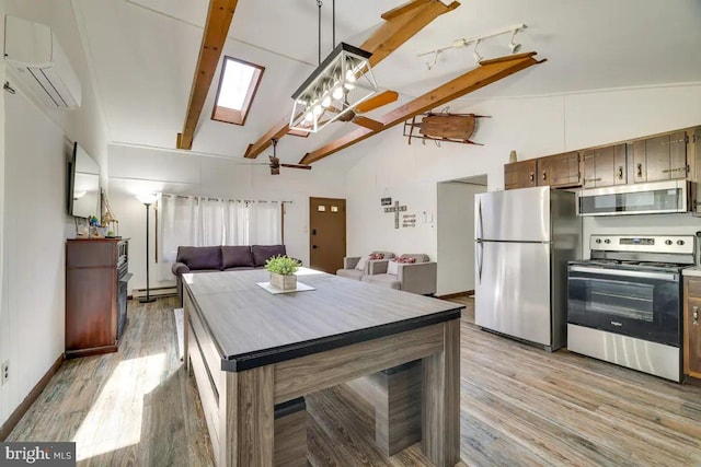 kitchen featuring light hardwood / wood-style floors, a wall unit AC, stainless steel appliances, and a skylight