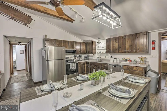 kitchen featuring sink, dark brown cabinets, stainless steel appliances, decorative light fixtures, and dark hardwood / wood-style floors