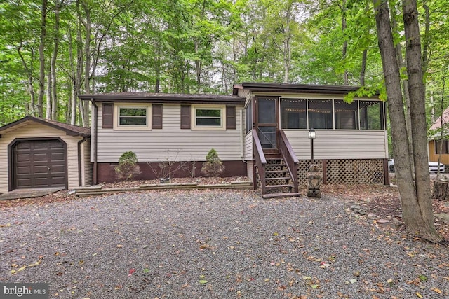 view of front of property with a sunroom, an outdoor structure, and a garage