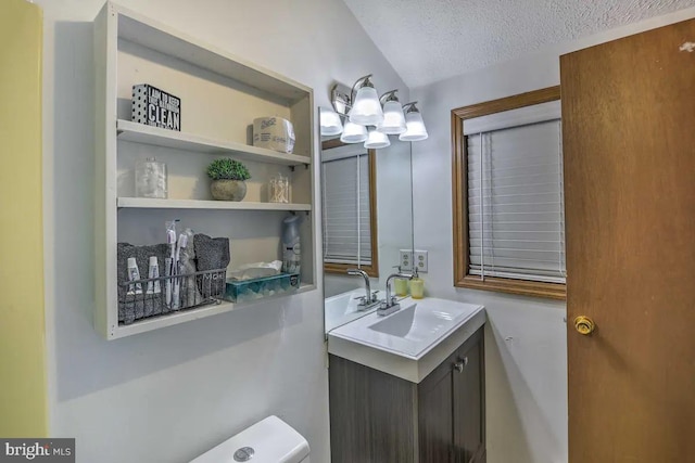 bathroom featuring vanity, a textured ceiling, and toilet