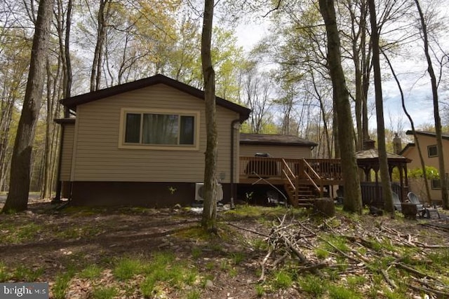 rear view of property featuring a wooden deck