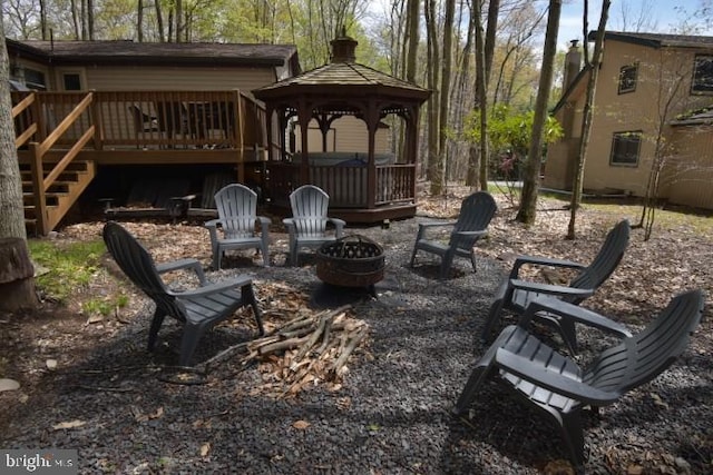 view of patio featuring a wooden deck, a gazebo, and an outdoor fire pit