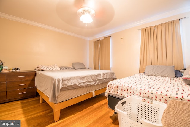 bedroom with ornamental molding, hardwood / wood-style floors, and ceiling fan