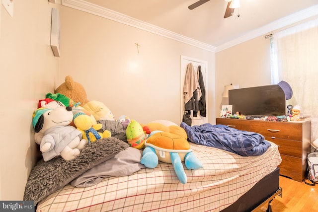 bedroom featuring light hardwood / wood-style floors, crown molding, and ceiling fan