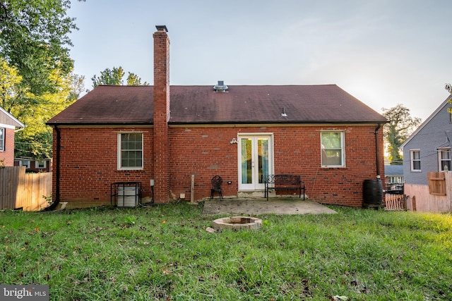 rear view of house with a yard, a patio area, and an outdoor fire pit