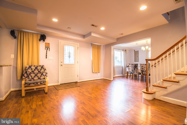 entrance foyer with hardwood / wood-style flooring and a chandelier