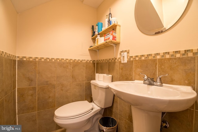 bathroom featuring tile walls, sink, and toilet