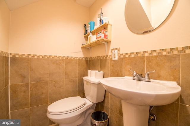 bathroom featuring tile walls, sink, and toilet