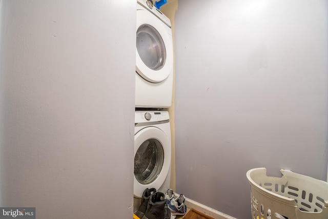 laundry room featuring stacked washer / dryer and hardwood / wood-style floors