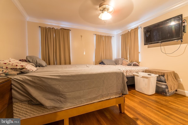 bedroom with ceiling fan, wood-type flooring, and ornamental molding