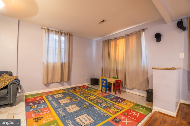 game room featuring beam ceiling and wood-type flooring