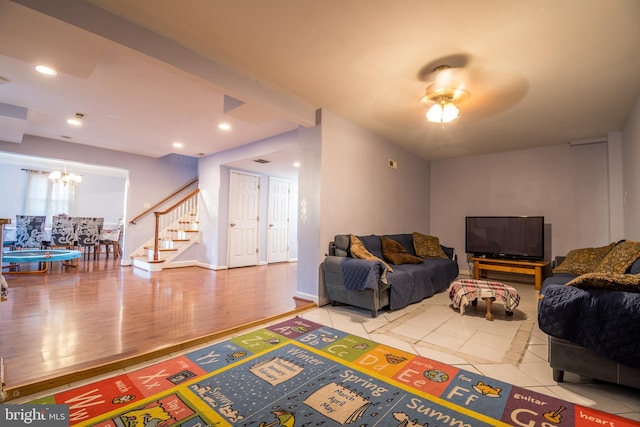 living room featuring hardwood / wood-style flooring and ceiling fan with notable chandelier