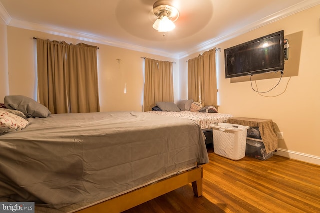 bedroom with hardwood / wood-style floors, crown molding, and ceiling fan