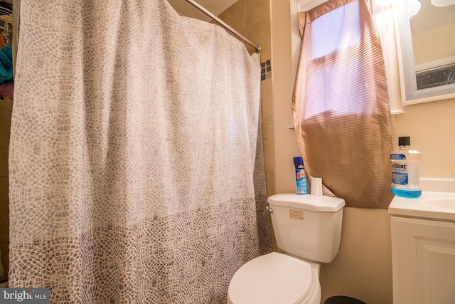 bathroom featuring vanity, toilet, and walk in shower