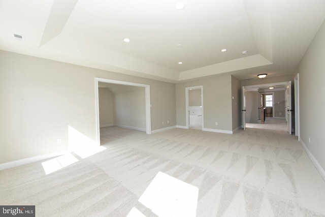 interior space featuring a raised ceiling and light colored carpet