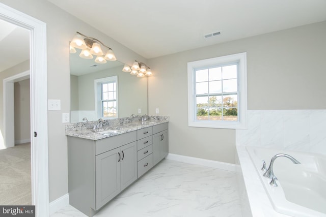 bathroom with vanity and tiled bath