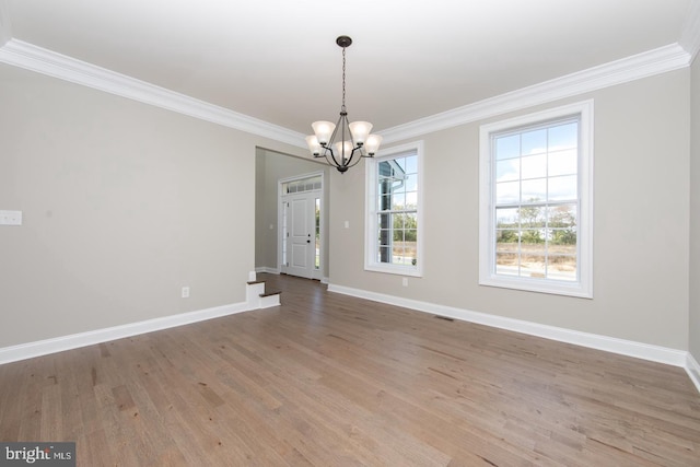 unfurnished dining area with crown molding, wood-type flooring, and an inviting chandelier