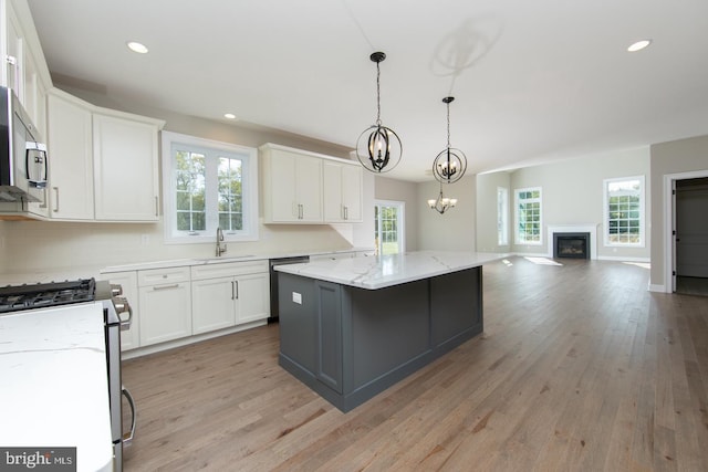 kitchen with appliances with stainless steel finishes, light hardwood / wood-style flooring, and plenty of natural light