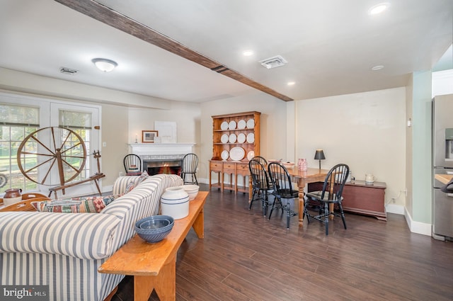 living room featuring beamed ceiling and dark wood-type flooring