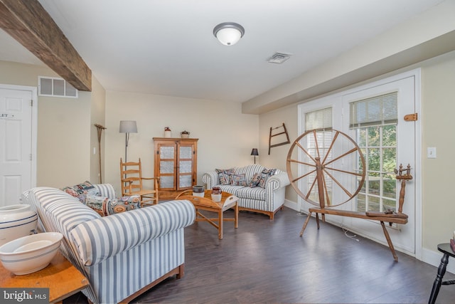 living room with beamed ceiling and dark wood-type flooring