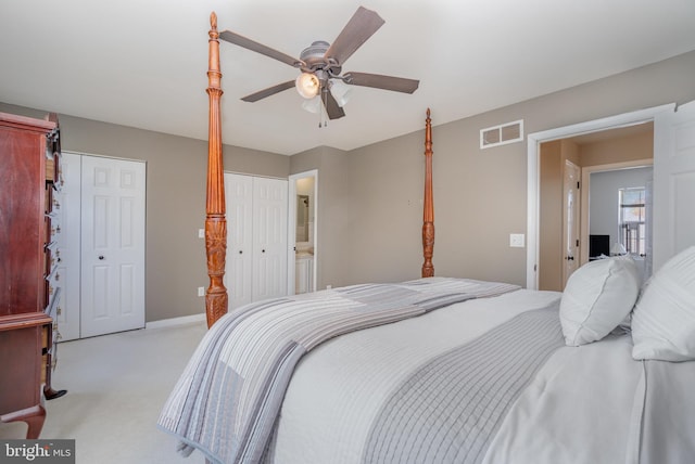 bedroom featuring ceiling fan, light colored carpet, and ensuite bathroom