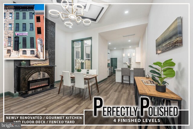 dining area featuring an inviting chandelier, wood-type flooring, and a fireplace