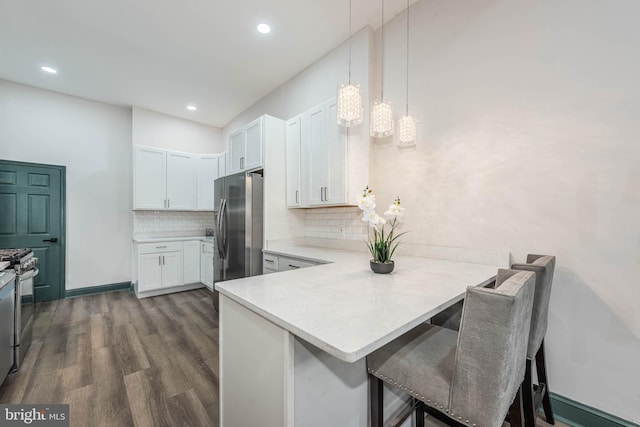 kitchen featuring kitchen peninsula, white cabinetry, hanging light fixtures, and stainless steel refrigerator