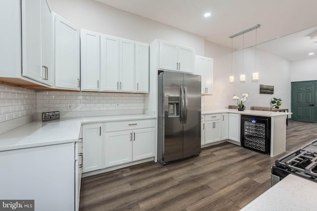 kitchen featuring dark wood-type flooring, hanging light fixtures, white cabinetry, beverage cooler, and appliances with stainless steel finishes