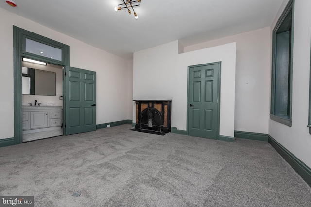 unfurnished living room featuring sink and light carpet