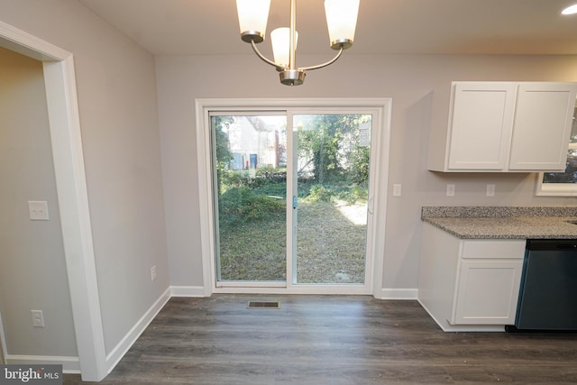 unfurnished dining area featuring a notable chandelier and dark hardwood / wood-style flooring