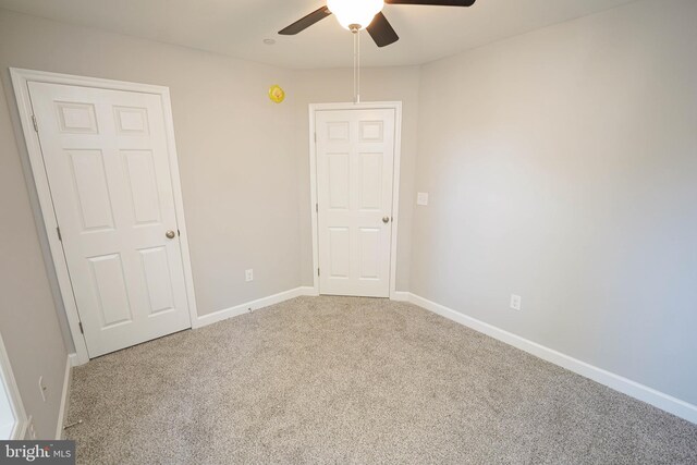 carpeted spare room with ceiling fan