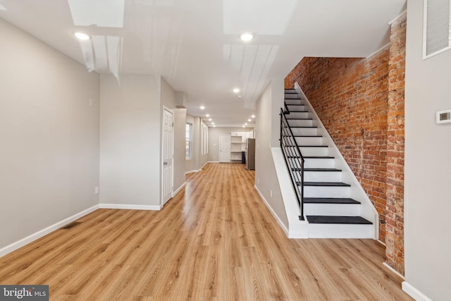 interior space featuring hardwood / wood-style flooring and brick wall