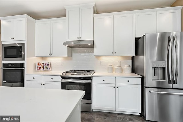 kitchen featuring white cabinets, stainless steel appliances, backsplash, and dark hardwood / wood-style floors