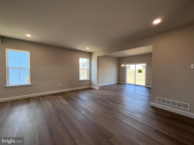 unfurnished room with recessed lighting, visible vents, baseboards, and dark wood-type flooring