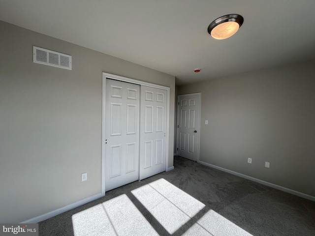 unfurnished bedroom with visible vents, carpet floors, baseboards, and a closet