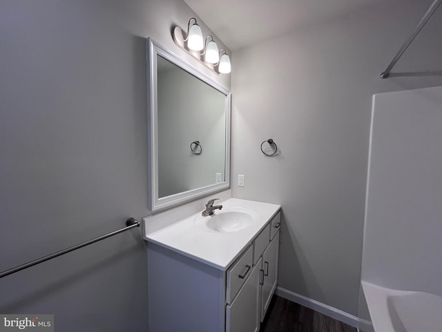 bathroom featuring vanity, baseboards, and wood finished floors