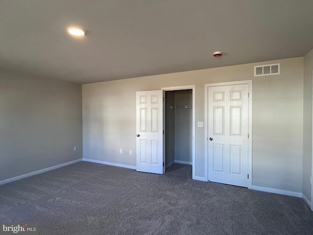 unfurnished bedroom featuring visible vents, baseboards, and dark colored carpet