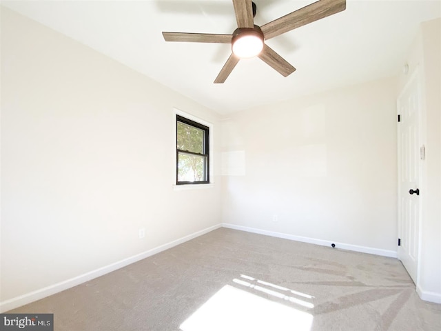 carpeted spare room with ceiling fan