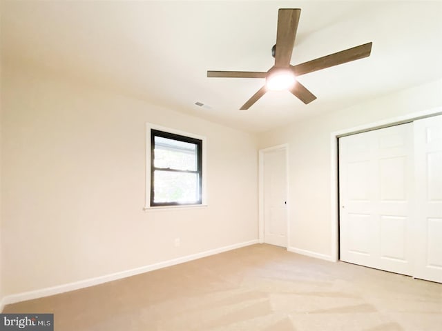 unfurnished bedroom featuring a closet, ceiling fan, and light colored carpet