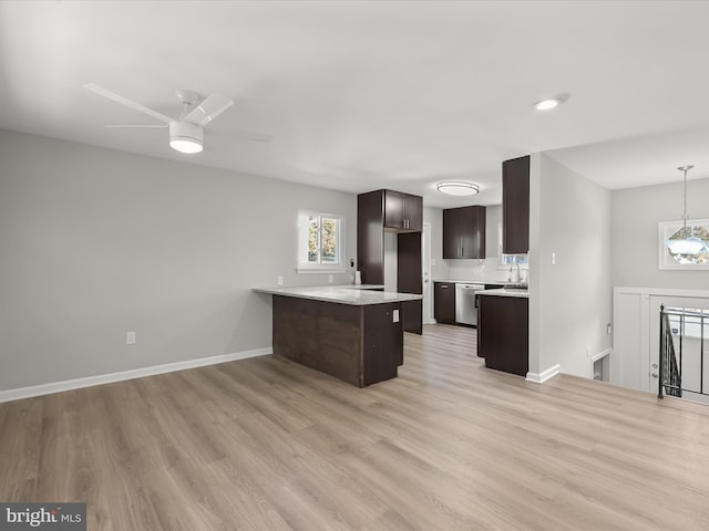 kitchen with dishwasher, light hardwood / wood-style flooring, hanging light fixtures, sink, and dark brown cabinetry