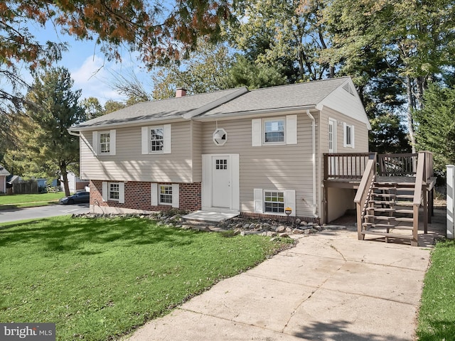 bi-level home with a wooden deck and a front lawn